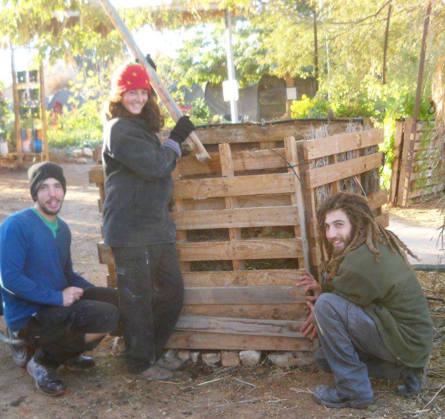 חברים מחזיקים קורות עץ בפתחי המשטח בזמן הידוק האדמה על מנת שלא תיפול החוצה