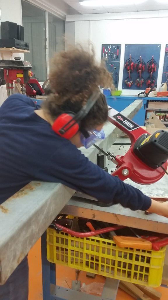 יערה המתנדבת המקסימה חותכת את הפרופיל 10x10 במסור הסרט