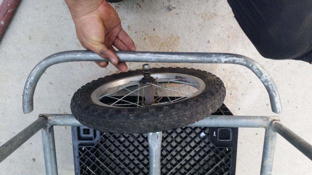 הגלגל עומד בתוך המקום היעודי לו - עם הצינור המכופף מוחזק ביד להמחשה