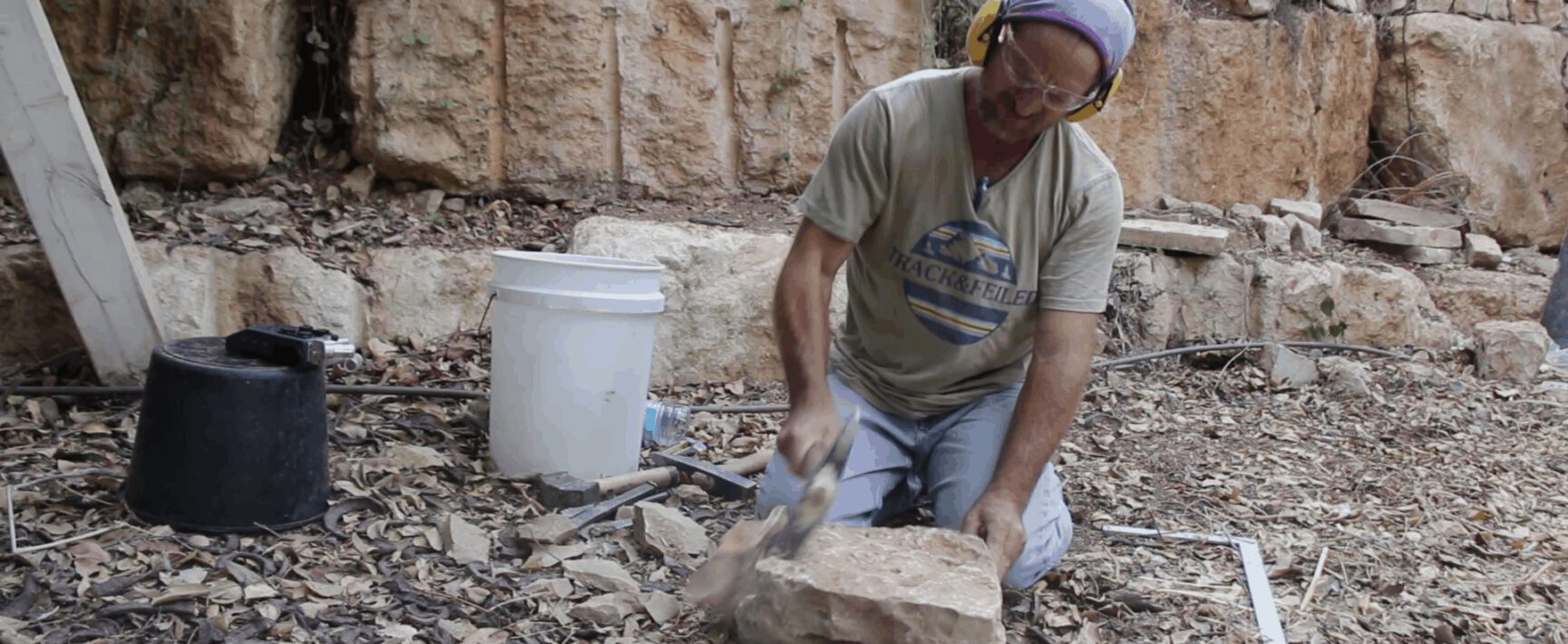 סיתות אבן בשטח עם אזמל ופטיש