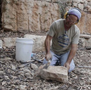 סיתות אבן בשטח עם אזמל ופטיש