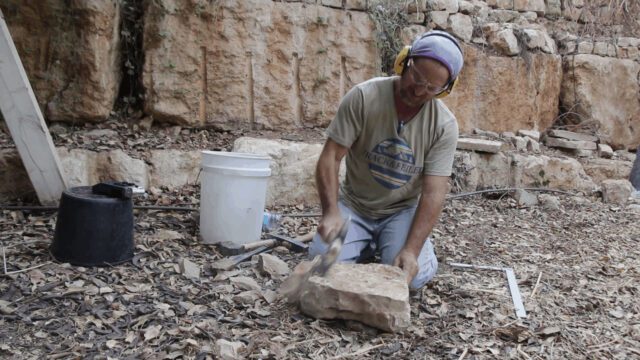 סיתות אבן בשטח עם אזמל ופטיש