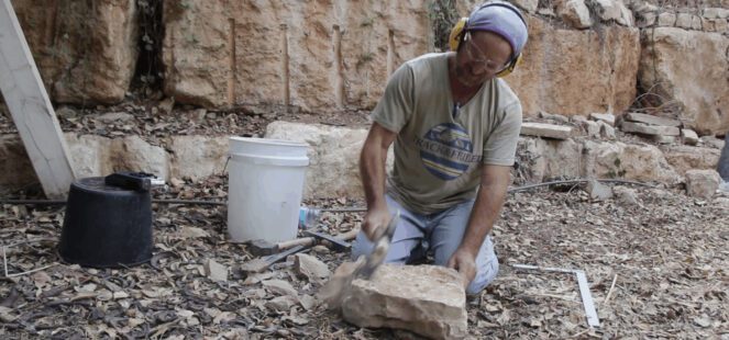 סיתות אבן בשטח עם אזמל ופטיש
